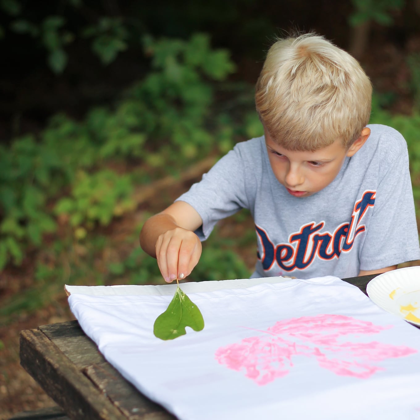 Child Stamping Leaves on T-Shirt